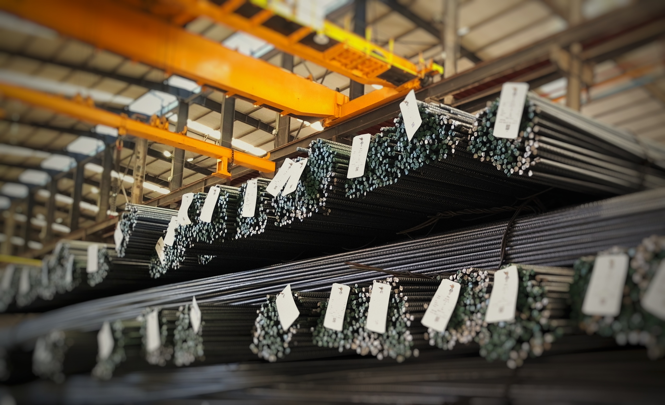 Overhead crane lifting tagged rebar bundles ready for dispatch